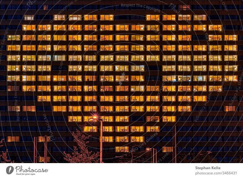 Heart shape illuminated windows of a building as a gesture for people who support others like now in hard corona virus times symbolically. heart architecture