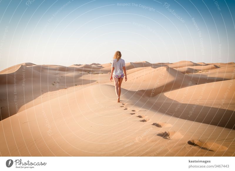 Blonde female Caucasian traveler leaving footprints in sand dunes when walking in dessert in Oman footsteps Sand Dessert Vacation & Travel Footprint Nature