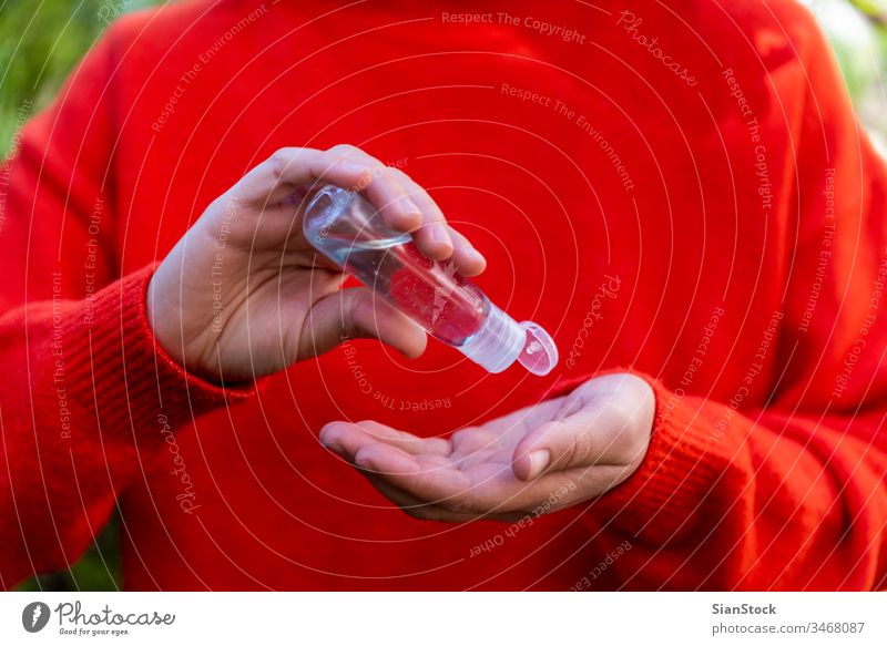 Close up woman hands using sanitizer gel dispenser, bacteria coronavirus influenza covid19 covid-19 avoid alcohol care liquid hygienic red outdoor plants green