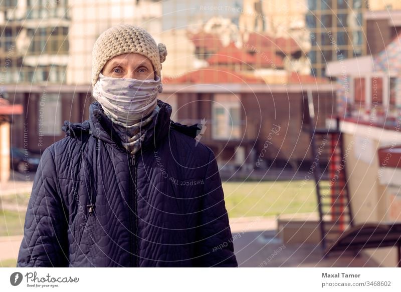 A poor elderly woman wears a homemade mask to protect herself from viruses more adult airborne respiration Building City Infection Contagious Corona coronavirus