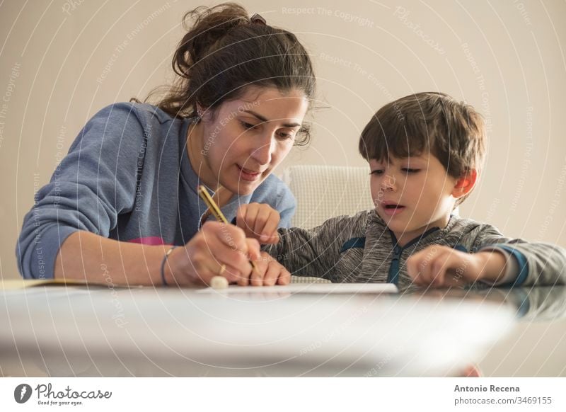 Mother helps little son to do homework at home mother children education woman family mother's day love write taught 4s 30s 40s lifestyle casual home indoor