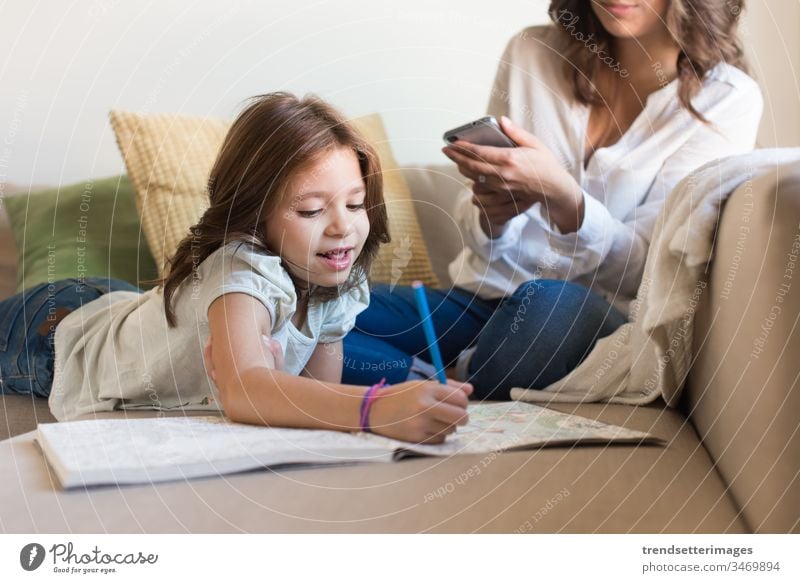 Girl painting with her mom chating smartphone mother family child woman mobile baby kid technology happy parent girl using little home indoors young smiling