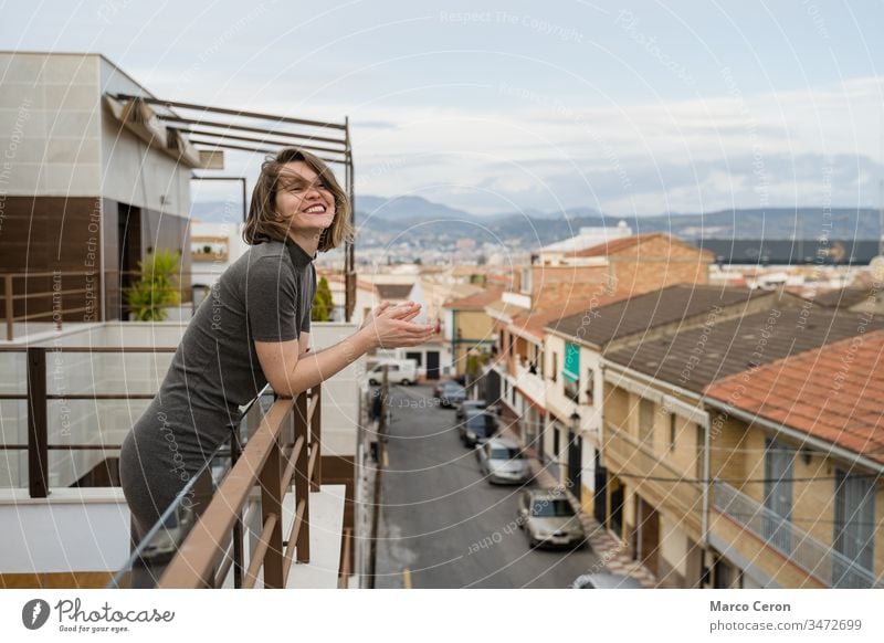 Young woman on qurantine spplauding to support health workers applauding clapping adult balcony applause community coronavirus greeting hands indoors quarantine