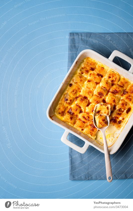 Cheese gnocchi in ceramic oven tray. Italian pasta with melted cheese baked food blue background cheese gnocchi cooked cream sauce dinner dumplings european