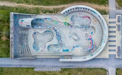 A skater court shot by a drone in vertical view. aerial sport park architecture down beton day morning no person aera skating rolling entertainment fun graffiti