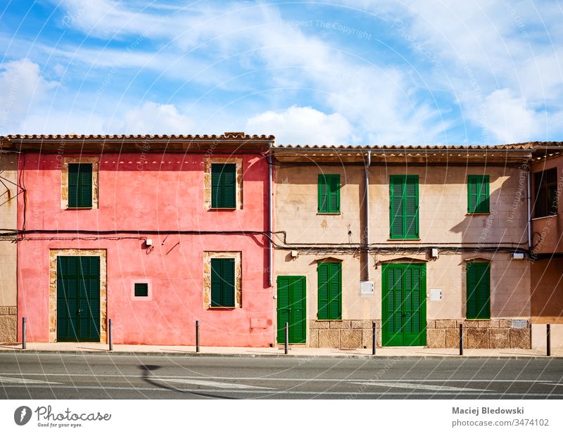 Old buildings with wooden shutters by a street in Alcudia, Mallorca. old house Spain window wall door architecture facade closed town sunny empty nobody bench