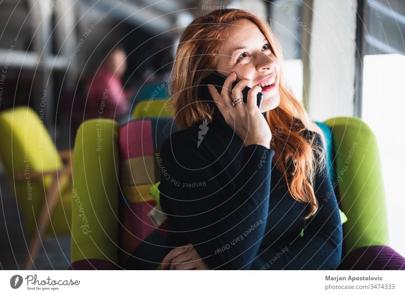 Young happy woman using smartphone in a cafe young smile indoor casual smiling table sitting lifestyle connected connection mobile communication wifi 30s cute