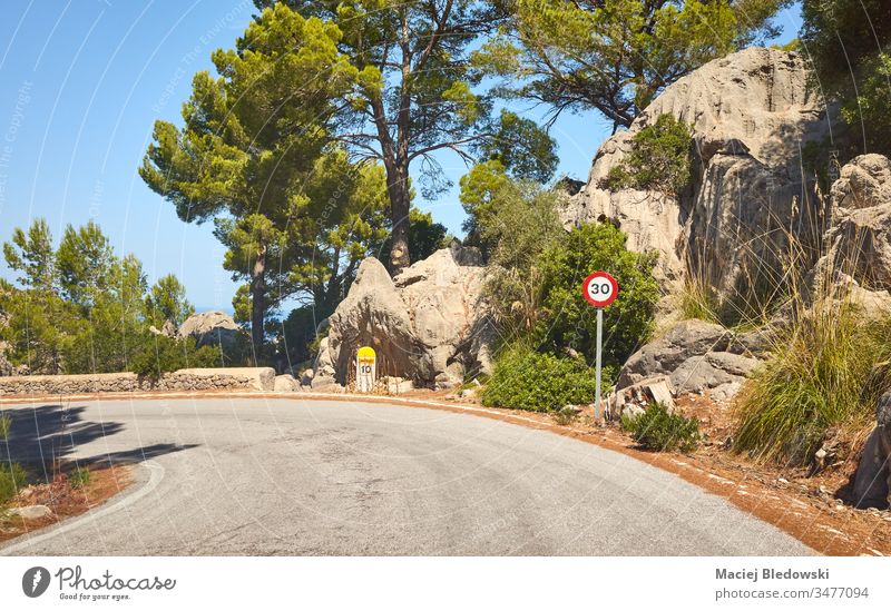 Scenic road with speed limit sign, Mallorca, Spain. drive journey trip mountain travel landscape nature traffic sign rock 30 curve tree