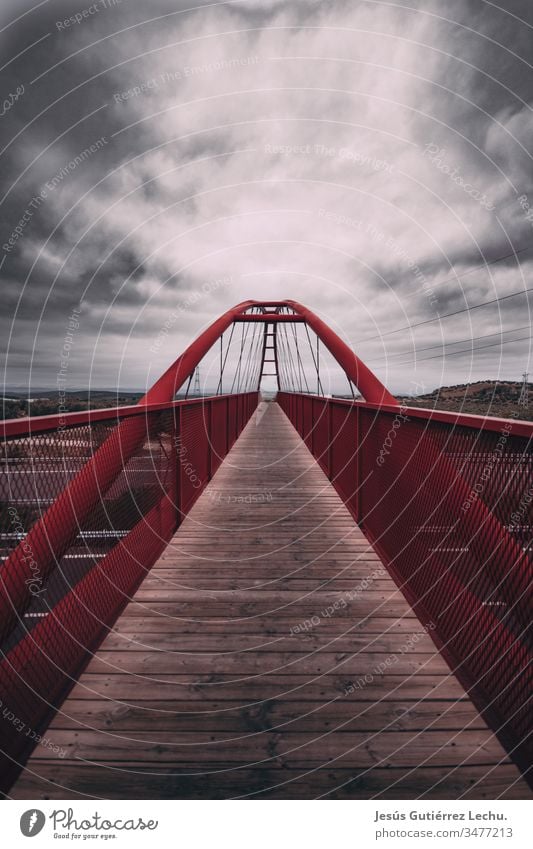 Red bridge with a long wooden path and a cloud sky red bridge Bridge railing Bridge construction pathway could sky Clouds in the sky skyline roads