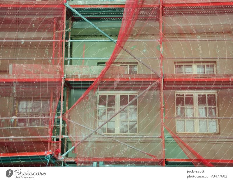 Renovation of the green facade with reddish scaffolding Construction site Facade Scaffold Covers (Construction) Authentic Protection Change Modernization