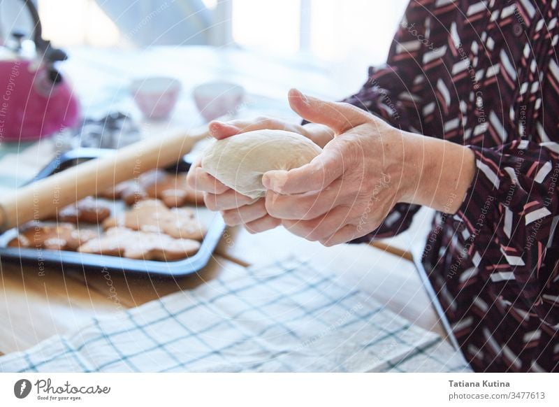 Female hands of an elderly woman knead the dough. Grandma makes cookies. Light background. female senior flour old table home kitchen baker aged preparation