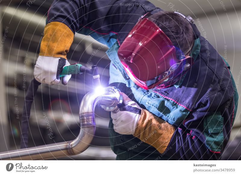 Industrial worker welding in metal factory. welder industry inox steel tube craftsman industrial manufacturing engineering stainless steel skill mask safety