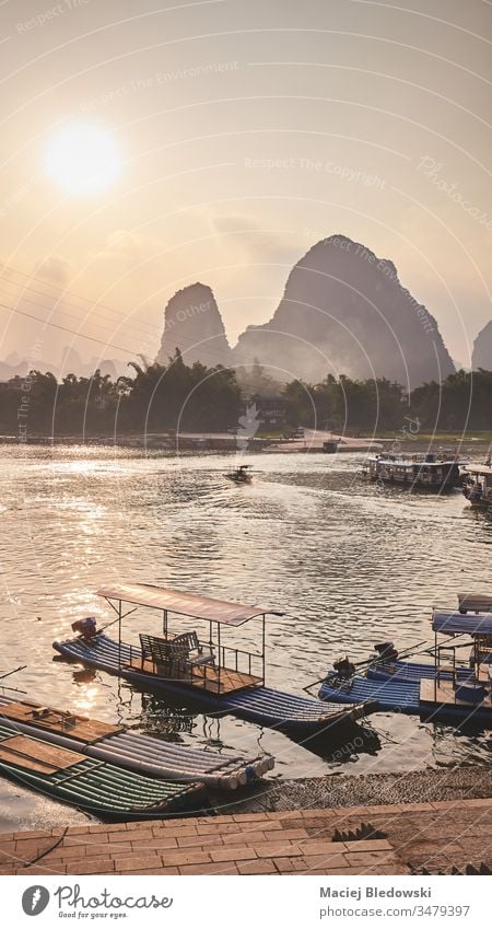 Bamboo rafts at Li River bank in Xingping at sunset, China. bamboo boat travel Asia beautiful dusk filtered hill karst landscape li mountain nature picture pier