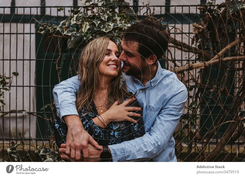 Happy couple in love hugging on street embrace city romantic together happy affection date kiss france bayonne urban bonding fence lifestyle cheerful tender