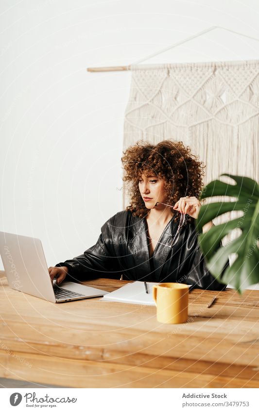 Retro businesswoman working in office laptop data read retro table leather sit project female vintage curly hair job gadget jacket device workplace professional