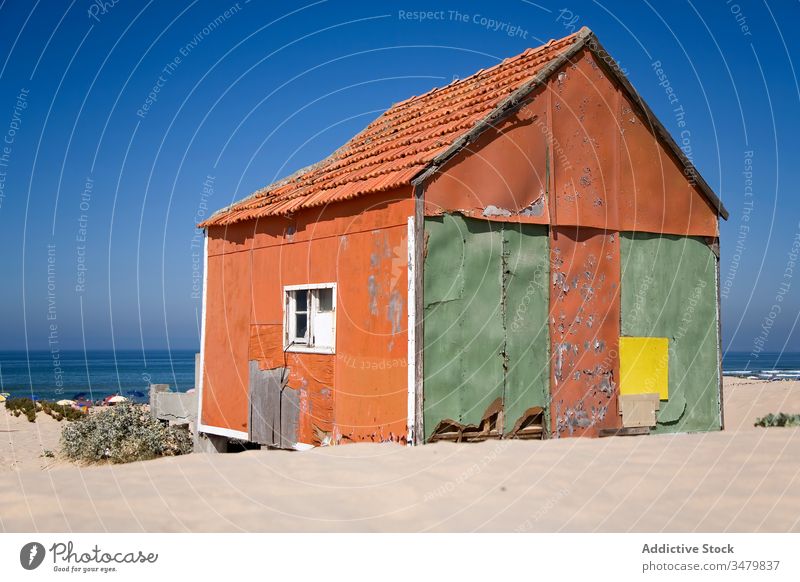 Old shabby house on sandy beach small coast building facade rural countryside exterior architecture sunny blue sky construction structure residential window
