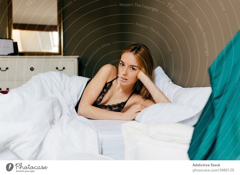 Young woman lying down in bed morning home underwear bedroom cozy female young relax comfort rest lingerie pillow lifestyle apartment lazy calm attractive