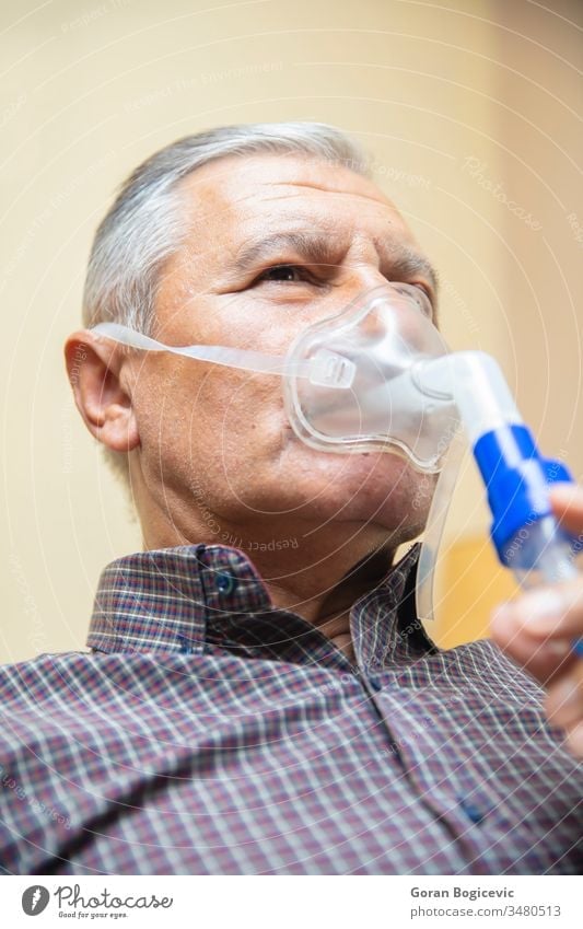 Senior man using medical equipment for inhalation with respiratory mask, nebulizer aerosol air allergy asthma asthmatic breath breathing bronchial bronchitis