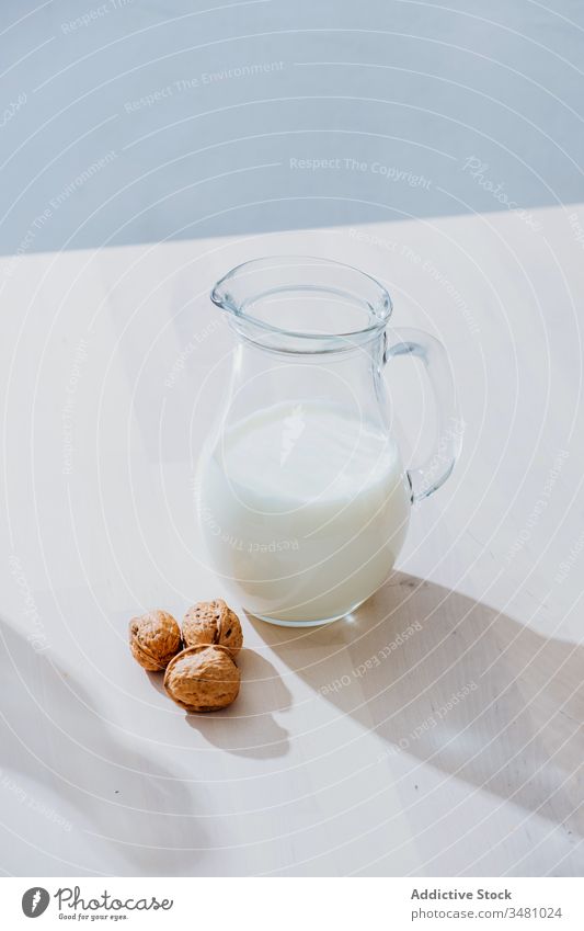 Jar of milk and nuts on table oat oatmeal jar vegan healthy natural nutrition food glass diet organic breakfast vegetarian drink ingredient morning cereal