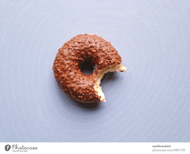 chocolate glazed donut or doughnut with bite missing half-eaten sweet food snack confectionery copy space copyspace dessert fresh indulgence unhealthy eating