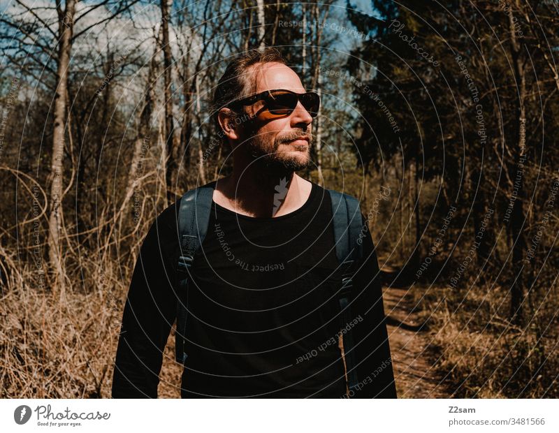 Young man hiking Hiking Man youthful Forest Nature Landscape Backpack free time Contentment Warmth Sun Summer Facial hair sunglasses Cool Exterior shot