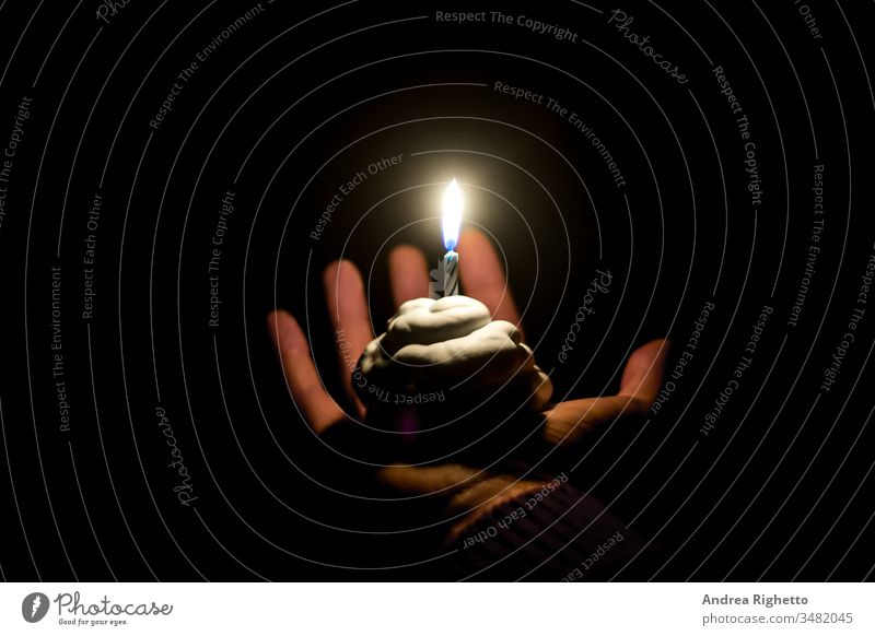 Sad birthday cake. Concept of sadness, feeling alone. Hand holding a birthday cake for one person with one candle Sadness sad birthday Birthday cake solitude