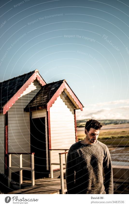 Man in a quiet place in Scandinavia Wooden house Meditative Manly Masculine good weather already Sunlight Downward Looking away thoughts Model Male masculinity
