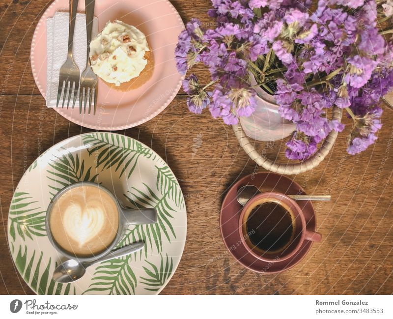 Cup of cappuccino with latte art and xpresso on a wooden plate and wooded table decorated with dried flower, Selective focus, Soft focus celebration piece fork