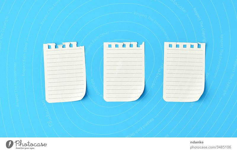 empty white sheets in a line torn out of notepad on a blue background above blank book business concept copy space diary document education flat list memo