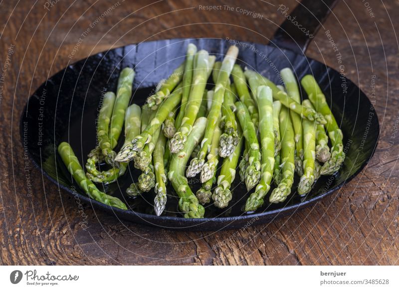 fresh green asparagus in a pan on dark wood Asparagus Pan Asparagus pan plank Wood Holiday season seasonal Gourmet string Kitchen Ingredients antioxidant