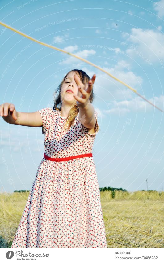 girl in summer dress reaches for a straw Child Girl Summer Field acre Summer dress Catch Grasp Action grasp at straws symbol symbolic