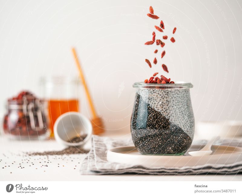charcoal two colors chia pudding with goji , copy space goji berries black glass idea white fresh breakfast dessert food healthy seed vegan berry diet dairy