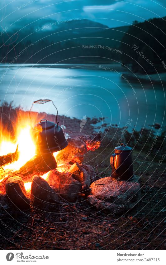 Campfire with coffee pot and kettle at a river in the wilderness at night campfire Coffee Coffee pot Water River outdoor Evening Night blue hour Wilderness