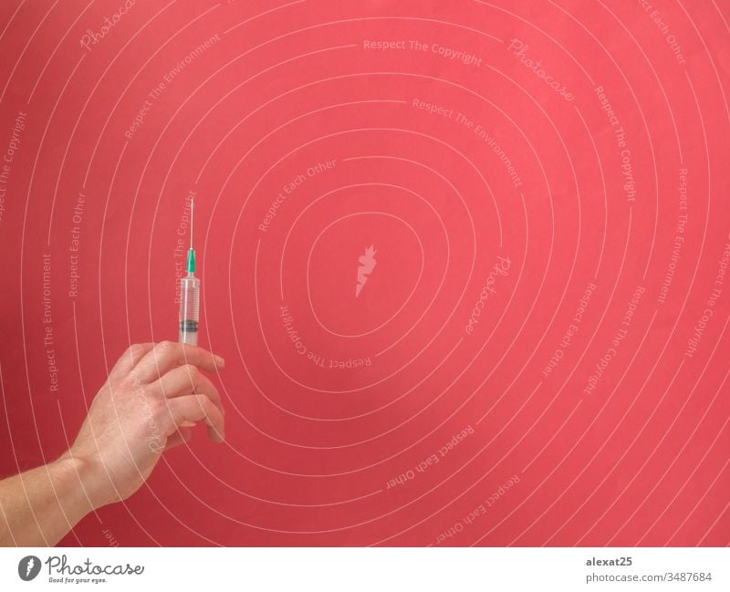 Hand with syringe on red background with copy space antibiotic coronavirus covid-19 disease dose drug epidemic equipment hand health healthy hospital illness