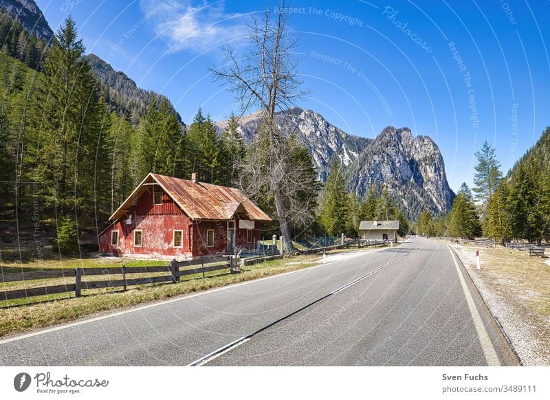 Red building on a road in an idyllic South Tyrolean landscape House (Residential Structure) Building Street mountains Forest Idyll Landscape Dolomites vacation