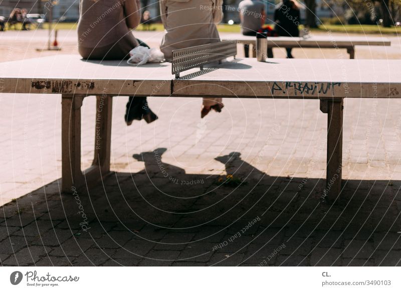 people sitting on table tennis tables Table tennis table Sit Break take a break Playground Lunch hour Park persons Relaxation Exterior shot Day Colour photo