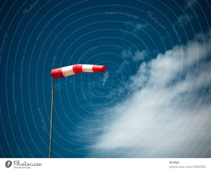 inflated windsock in strong wind in front of blue sky and clouds Windsock Wind direction Reddish white Blue direction indicator Blow Beautiful weather Deserted