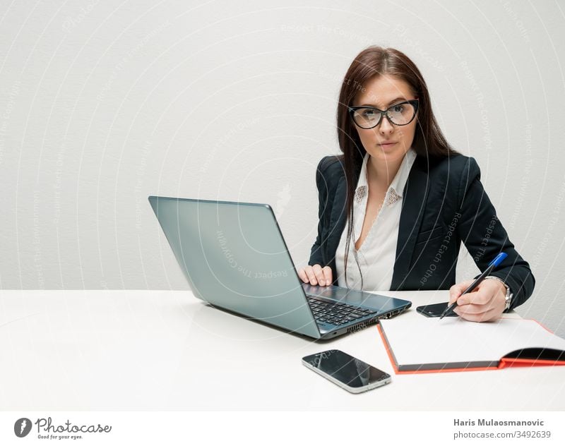 Businesswoman working in office with attitude looking at the camera  with laptop and mobile phone agent ambitious assistant attractive beautiful business