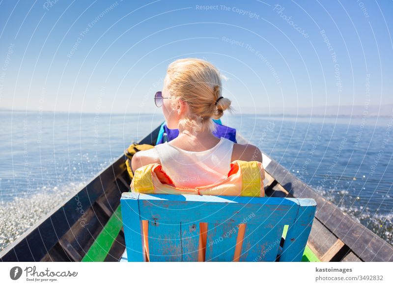 Female tourist travels by traditional boat. water woman lake rear female vacation transportation sea sky journey life nature outdoor safety leisure destination
