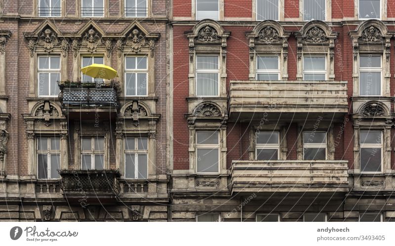 The yellow parasol on the balcony of the old house ancient antique apartment arch architecture balconies Berlin brick wall building building exterior