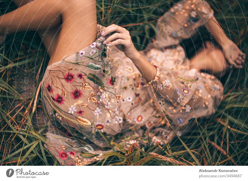 Young woman in transparent dress with flowers lie on a grass with her arm on her face Youth (Young adults) romantic romantic mood fresh hand knee Dress