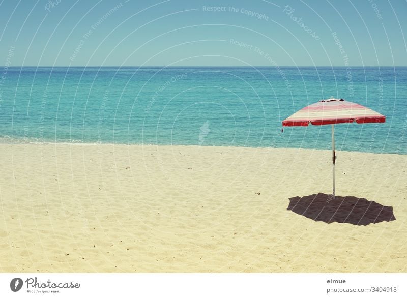 empty sandy beach with a parasol in front of blue sea in sunshine Sandy beach Beach Wanderlust Ocean Sunshade Deserted Water Empty orphan Summer