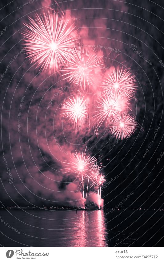 Luxury fireworks event sky water sea show with red stars. Premium entertainment magic star firework at e.g. New Years Eve or Independence Day party celebration. Nice lake surface reflections