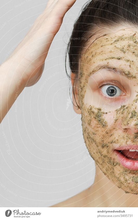 Skin Care. Cosmetic Day. young girl in home style, her hair gathered with her hands at the top. With eco, herbal, natural mask, green on the face. Front view.