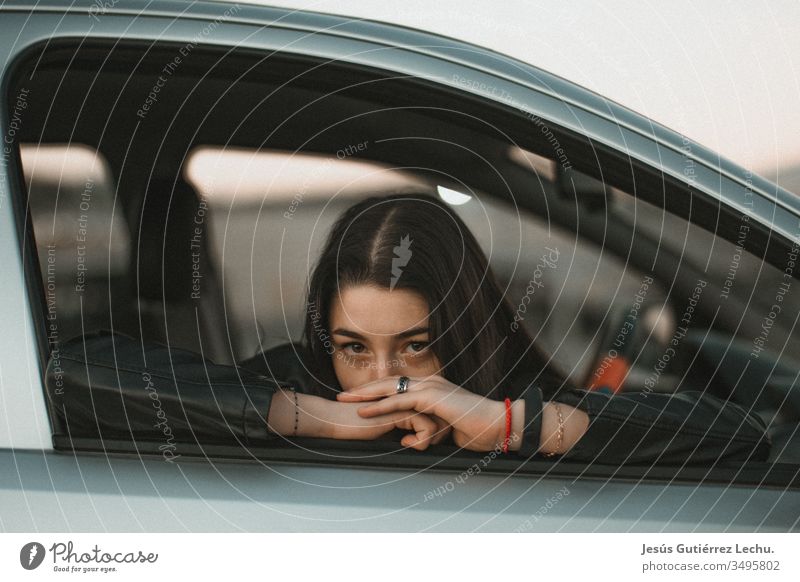 young girl leaning against the window of a gray car Human being Driver Travel photography Portrait photograph Vintage girls Life coche Beautiful Cute Model