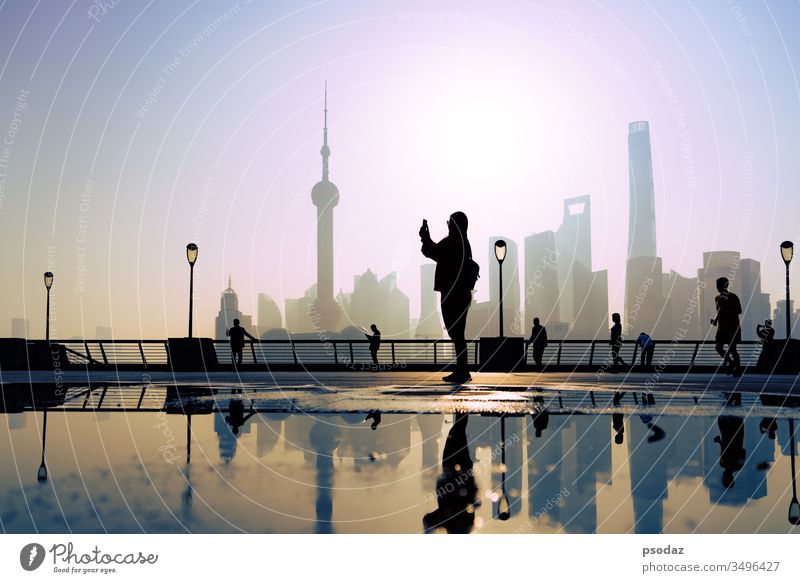 traveler take a photo of morning activity at the bund, huangpu riverside,  shanghai city view background ancient architecture beautiful building business china