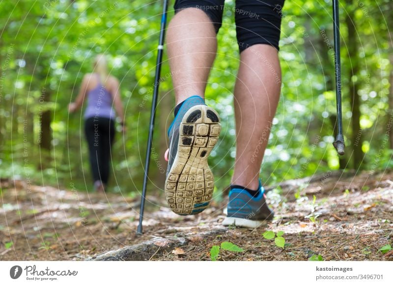 Young couple hiking in nature. Sport and exercise. nordic walking sport trek park people step training jogging adventure woods forest workout leisure female