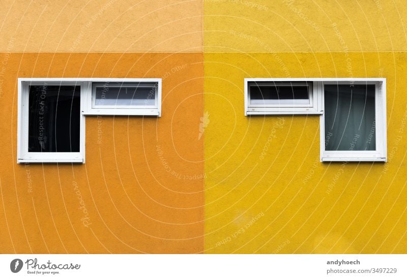 A pair of two windows on a yellow and orange facade abstract apartment architecture Background Berlin building building exterior built structure checkerboard