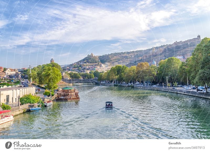 pleasure boat on the waves of the Kura River in Tbilisi Georgia Caucasus Georgia country autumn bank bedpan brige bright city cityscape craft downtown