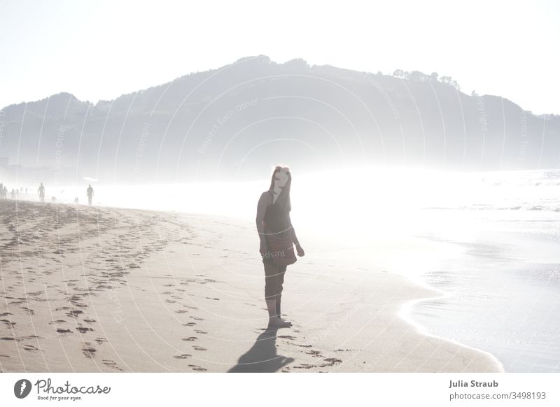 Woman walking on the beach Beach Sandy beach Ocean Silhouette Back-light Footprint Spain zarautz Basque Country Review Warmth hazy Water Barefoot Waves vacation